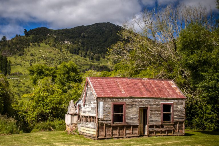 Abandoned cabin sitting in mowed field, New Zealand