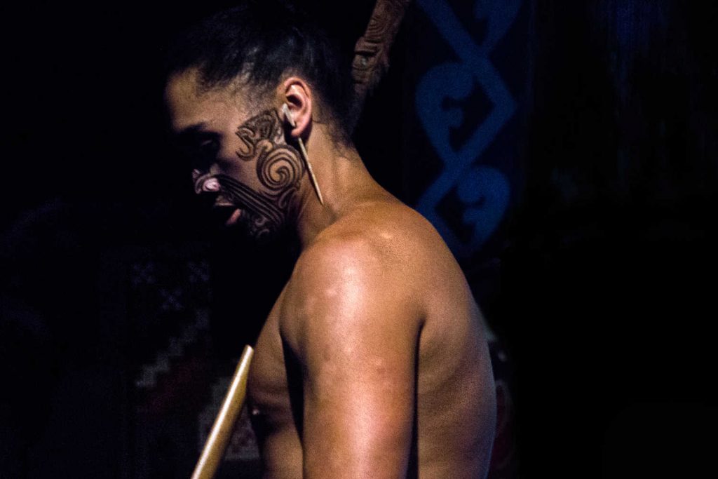 A portrait of a Maori man in traditional clothing and facial tattoos in Rotorua