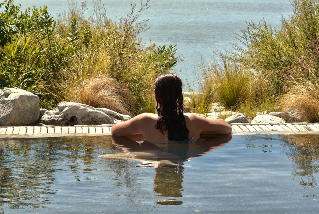 Young woman having a spa in outdoors hot pool in Rotorua, New Zealand.