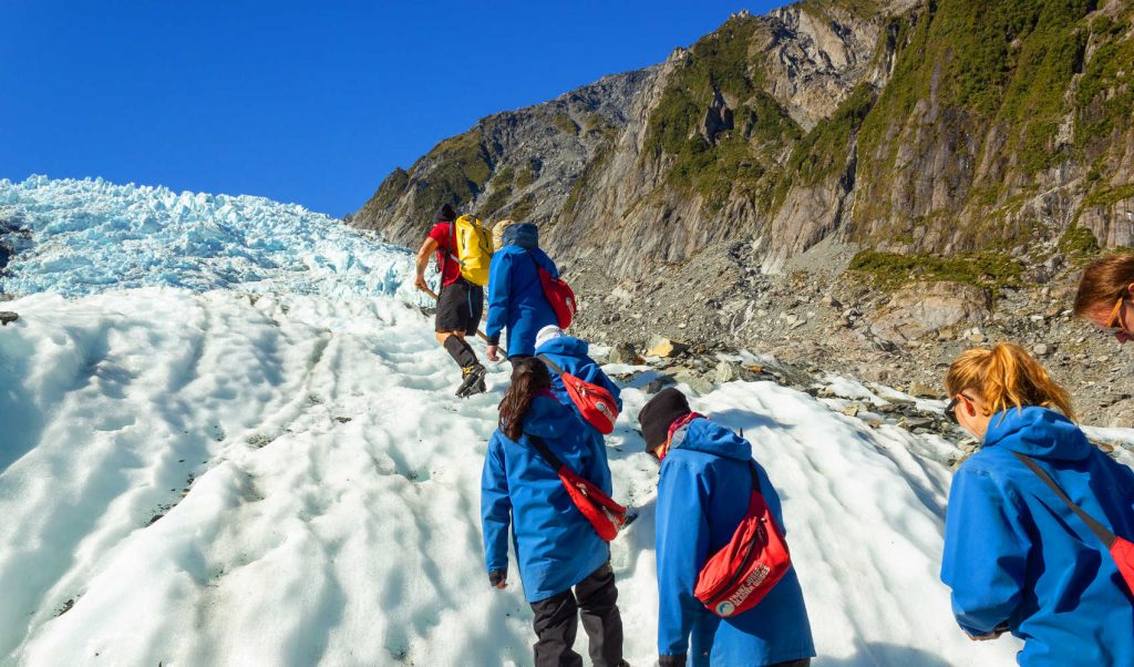 Franz Josef, New Zealand. A group of tourists hiking on Franz Josef Glacier
