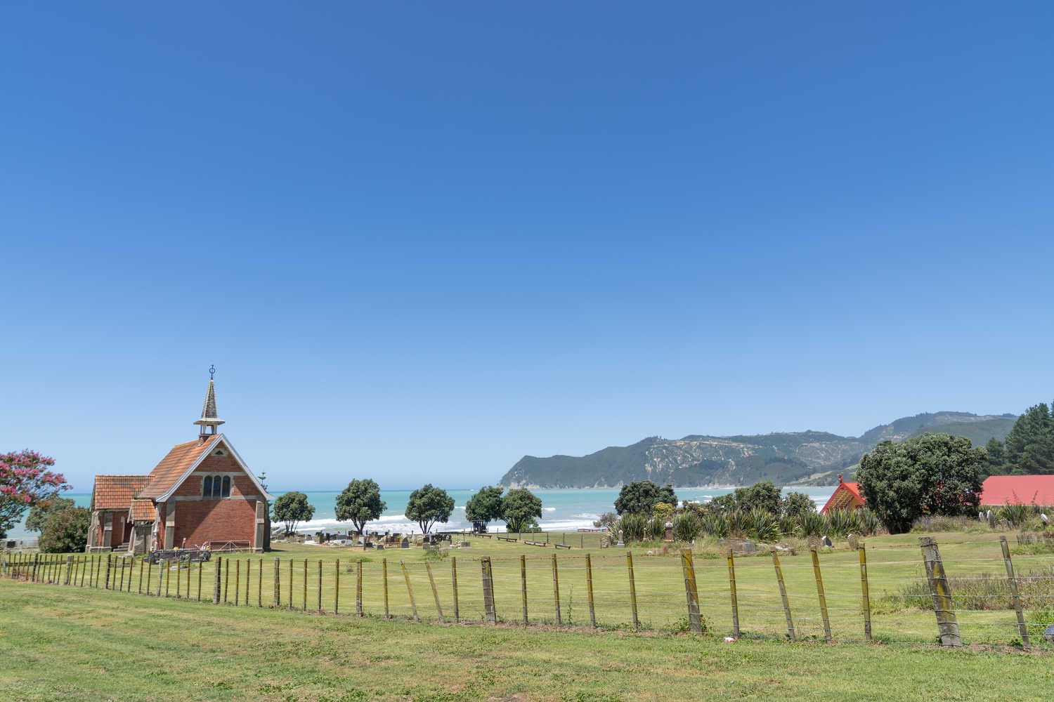 St Abraham`s Anglican Church on top of rise by sea at Waipiro Bay, New Zealand