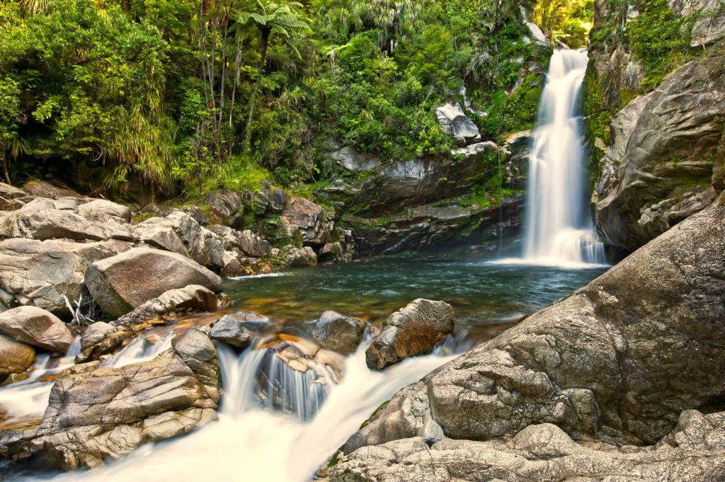 Wainui Falls, Abel Tasman National Park, South Island, New Zealand in daylight and slow shutter speed during southern hemisphere summer in February