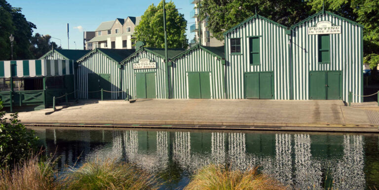 Boatsheds along and reflected in Avon River in the city, NZ